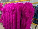 Des plumes roses sont suspendues à un portemanteau dans un magasin de vêtements