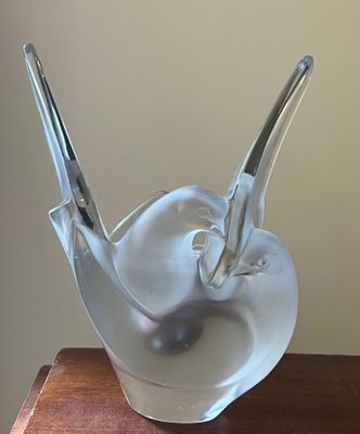 une sculpture en verre représentant un oiseau posé sur une table