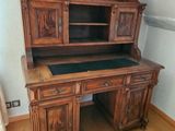 a wooden desk with a black top in the corner of a room