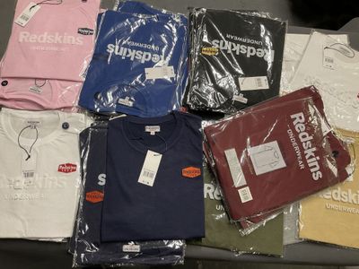 un grand nombre de t-shirts posés sur une table