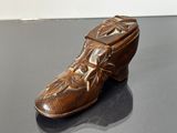 une boîte à chaussures en bois ornée d'un motif sculpté, posée sur une table