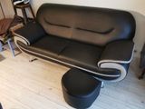 a black and white leather couch and ottoman in a living room