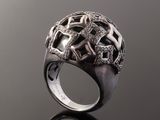 a close up of a ring with diamonds on a black surface