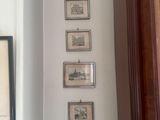 des tableaux accrochés au mur d'un couloir dans une maison