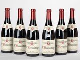 six bouteilles de vin rouge alignées sur une surface blanche