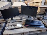 two computer monitors and a keyboard on a pallet