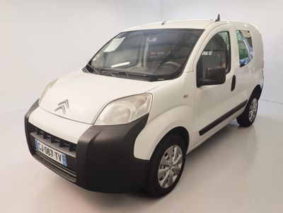 une petite camionnette blanche aux finitions noires garée dans une pièce blanche