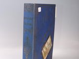 an old blue book sitting on top of a white table