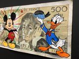 a picture of a mickey mouse and donald duck on a bank note