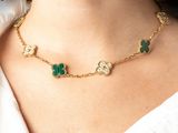 the woman is wearing a necklace with four clovers on it