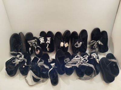 Plusieurs paires de chaussures noires et blanches sont alignées sur une étagère