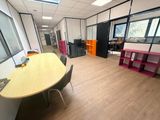 une pièce avec une table, des chaises et une grande fenêtre