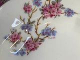 a white plate with pink and blue flowers on it next to a white plate with pink and blue flowers on it