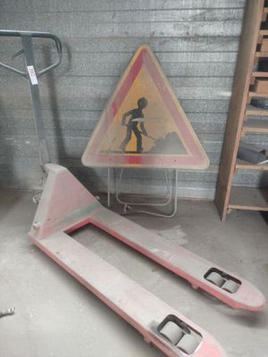 a pink forklift with a sign on it in a garage