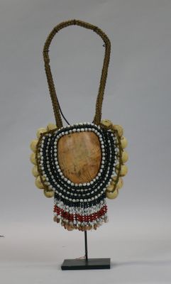 a close up of a necklace with beads and beads on a stand