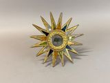 an image of a gold sunburst with green and blue stones