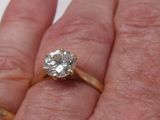 la main d'une personne tenant une bague sertie d'un diamant