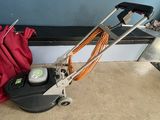 a machine that is sitting on the floor next to a red bag