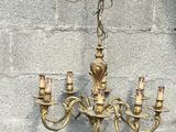 un lustre suspendu à une chaîne fixée à un mur en briques