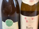 three bottles of wine are lined up on a table