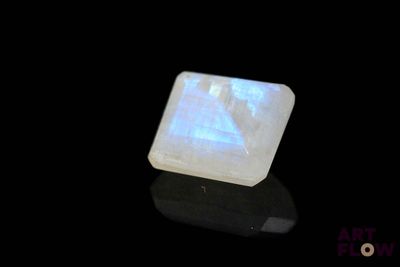 un gros plan sur une pierre blanche carrée sur laquelle brille une lumière bleue