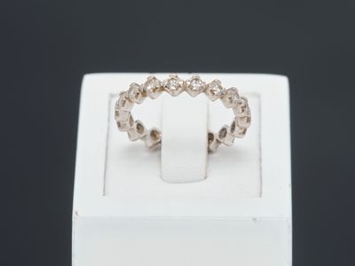 un gros plan d'une bague posée sur une boîte blanche, sur fond noir