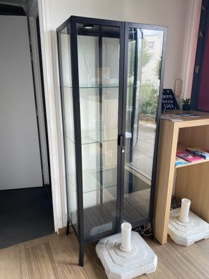 une vitrine en verre dans le coin d'une pièce
