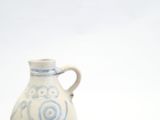 a blue and white vase sitting on a white surface