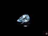 a close up of a blue diamond on a black surface