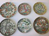 six assiettes chinoises aux motifs variés posées sur une table