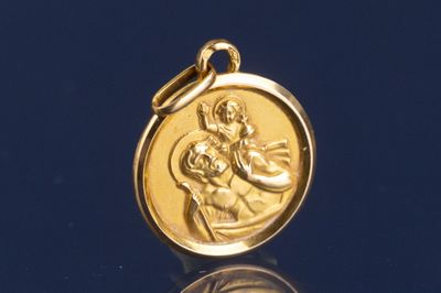 une photo d'une médaille d'or sur laquelle figure une image de la Vierge à l'Enfant