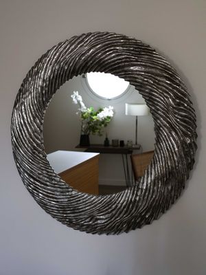 a round mirror hanging on the wall in a room