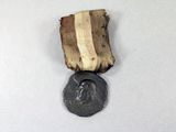 an old medal with a bronze medal on a white surface