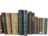 many old books lined up on a shelf together