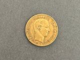 a gold coin with a profile of a man ' s head on it