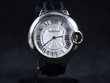un gros plan d'une montre avec des chiffres romains sur fond noir