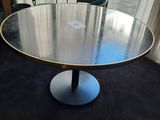 une table ronde avec deux chaises vertes devant une fenêtre