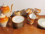 many plates and cups on a table with a teapot