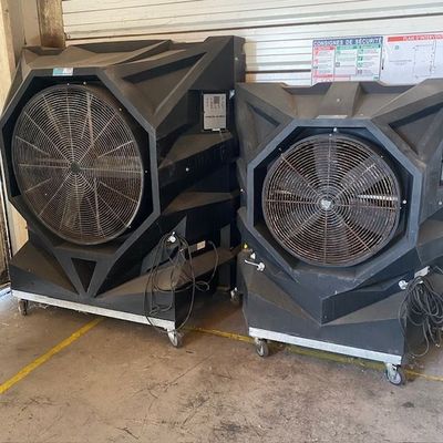 deux ventilateurs qui sont rangés dans un garage