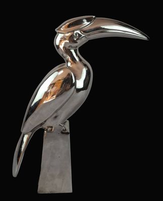 une image représentant un oiseau argenté posé sur un bloc de bois