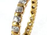 a close up of a gold and diamond ring on a white surface