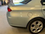 a silver car parked in a garage with other cars in the background