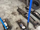 two jacks that are sitting on the ground next to a pile of tires