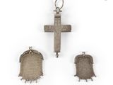 three pieces of silver jewelry including a cross and a bell