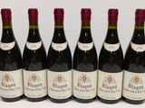 six bouteilles de vin rouge sont alignées sur une surface blanche