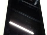 une tablette posée sur une table blanche