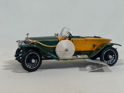 a green and yellow model of a car on a white surface
