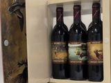 trois bouteilles de vin dans un coffret en bois sur une table