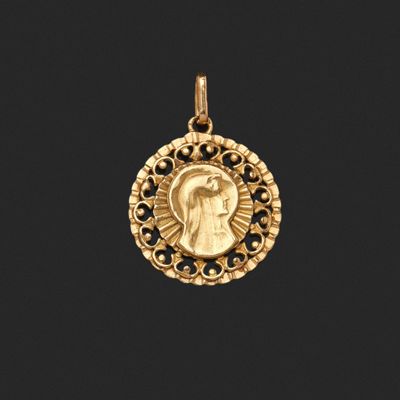 un pendentif en or sur lequel est représenté Jésus