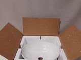 a white bowl inside of a cardboard box on a table